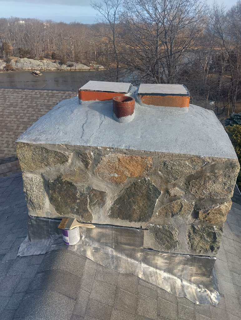 Restored stone chimney with new crown and flashing