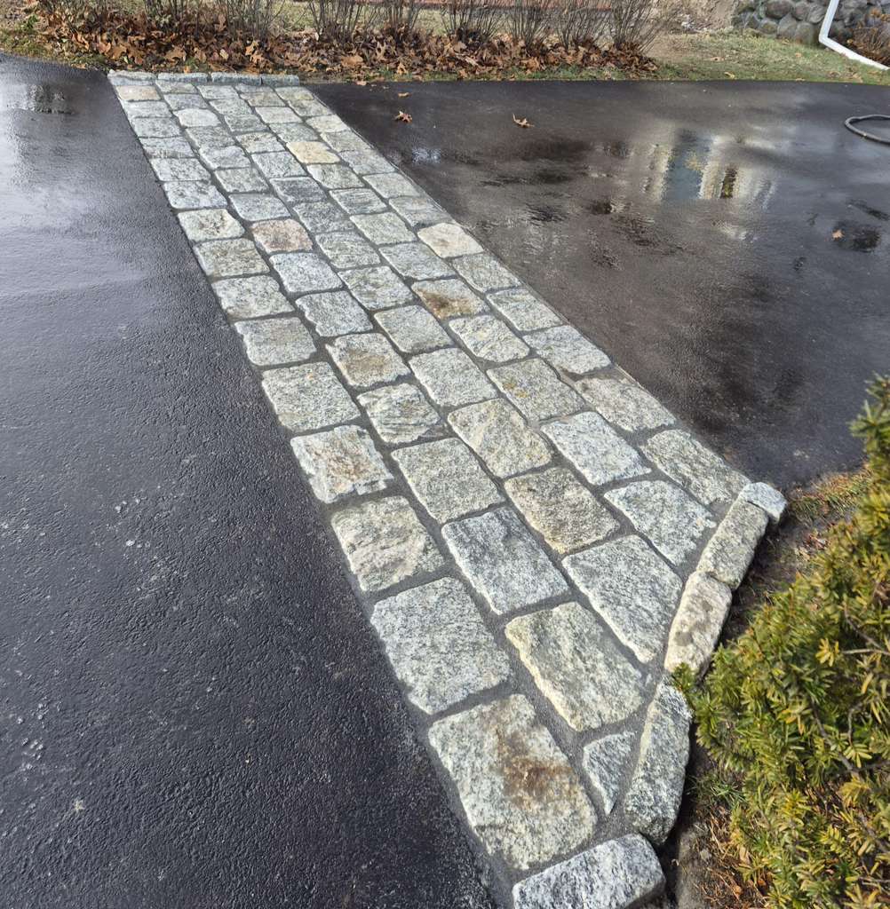Granite cobblestone walkway crossing an asphalt driveway